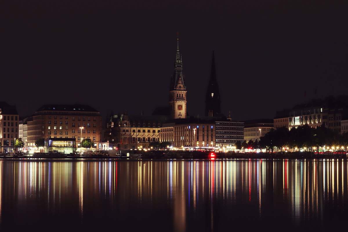 building body of water across city building during nighttime spire