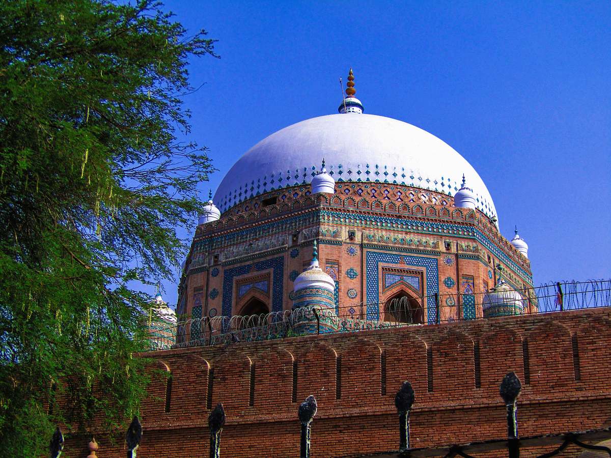 building brown and white dome building surrounded with tall and green trees dome