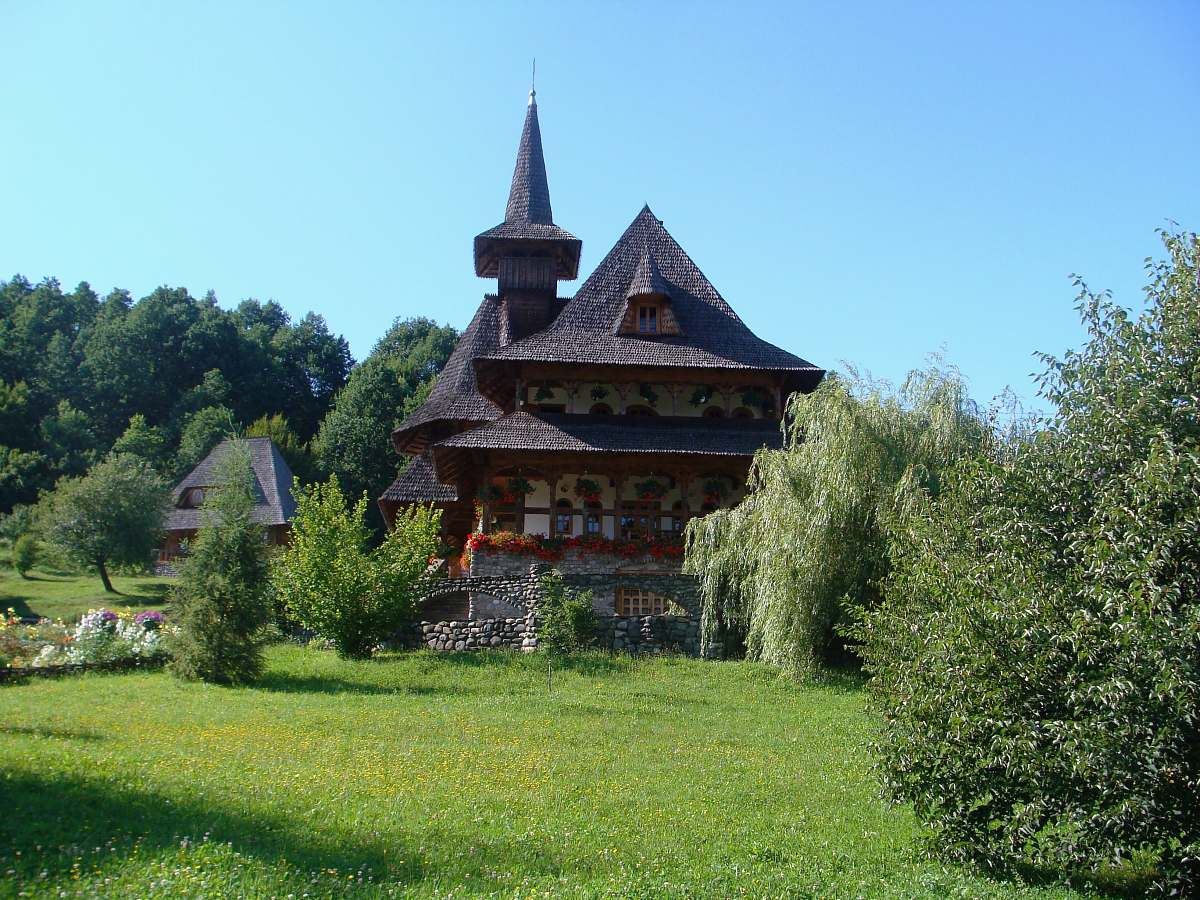building brown and white house surrounded by green trees at daytime spire