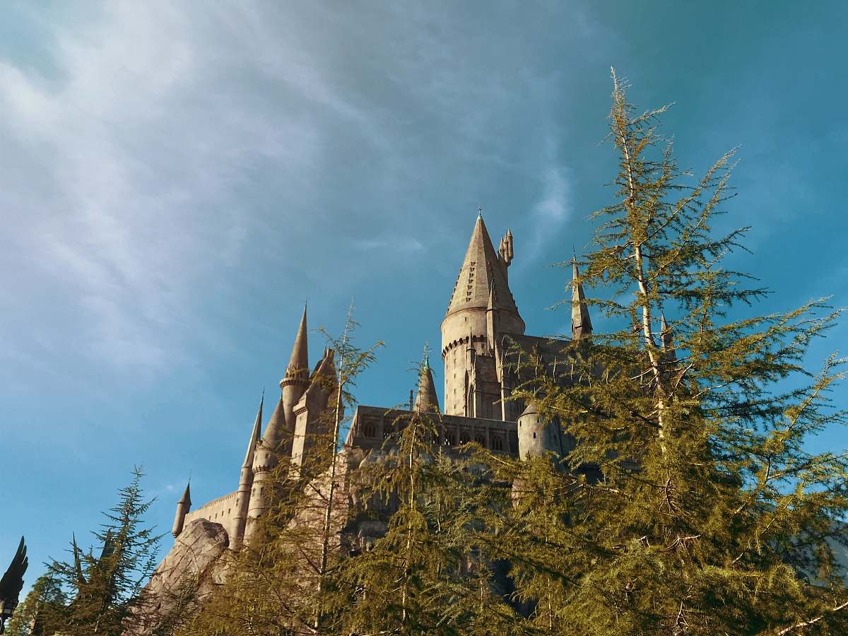 building brown castle under white clouds spire