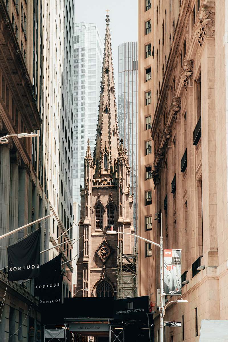 building brown cathedral seen in between buildings spire