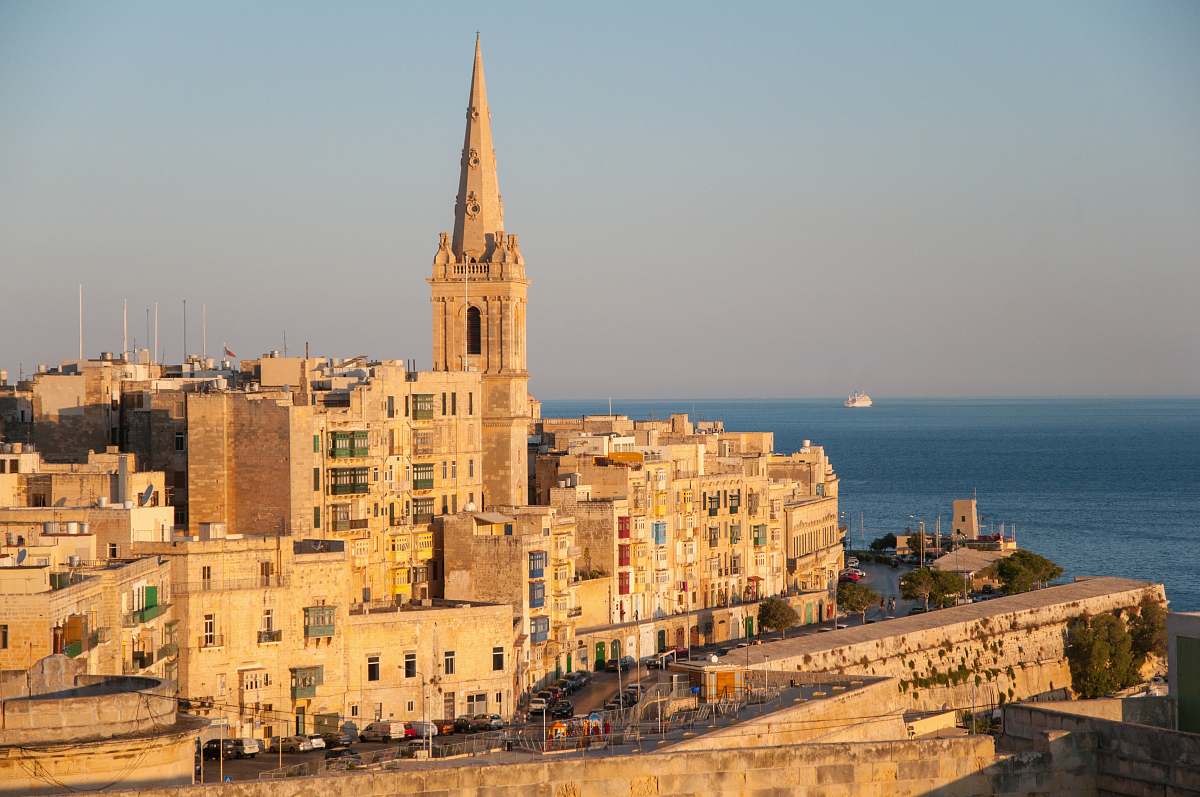 building brown concrete cathedral near sea during daytime spire