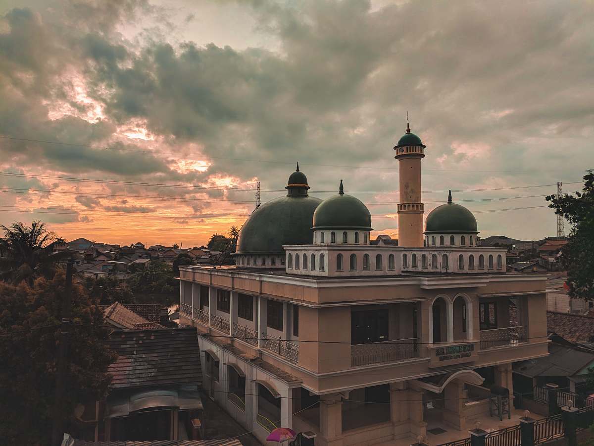 building brown concrete mosque surrounded by trees during sunset dome