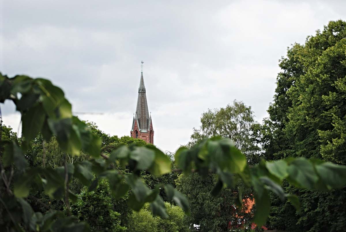 building brown concrete tower near trees spire