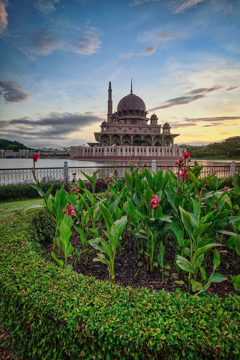 building brown dome building viewing pink flower garden under blue and white skies dome