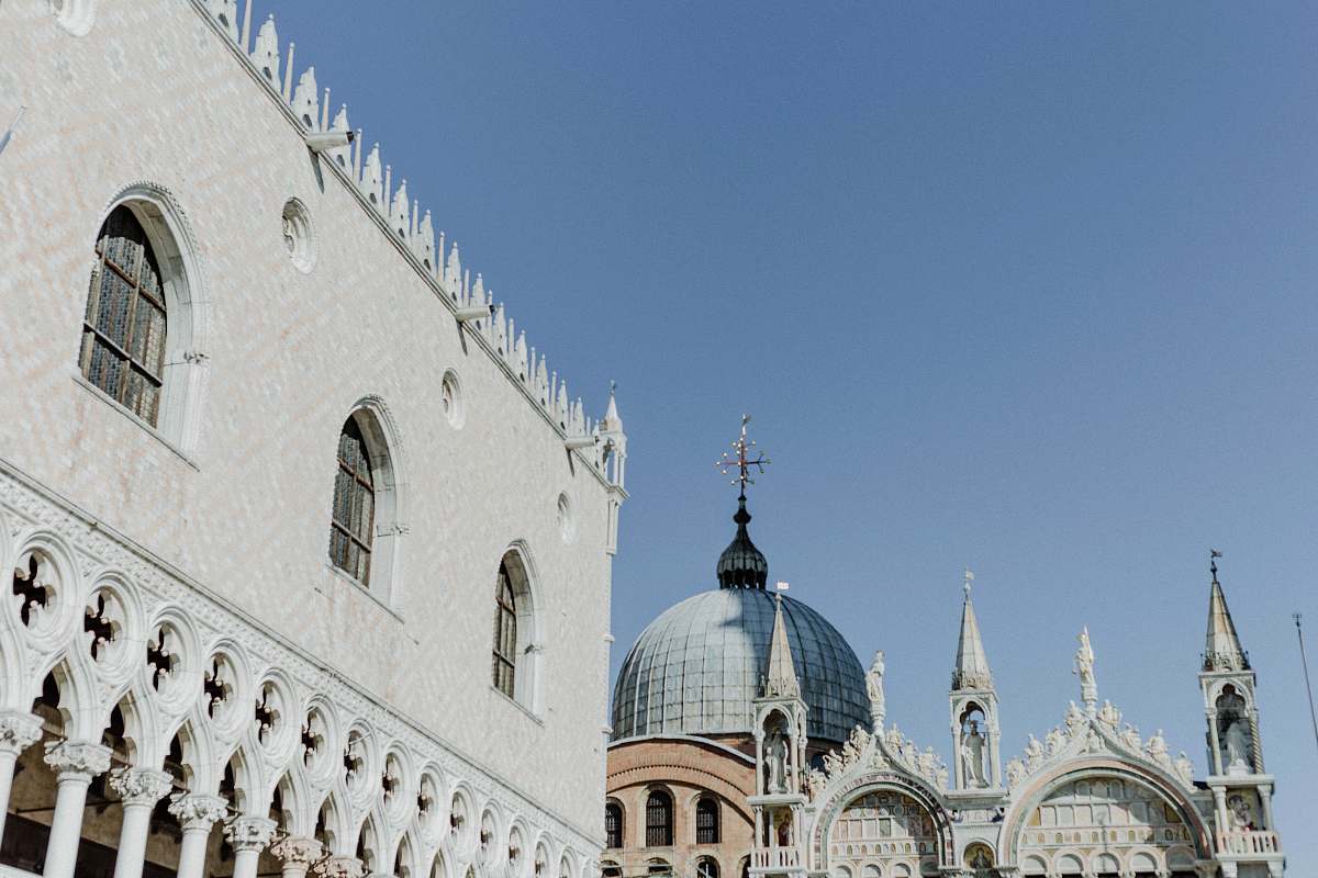building cathedral beside white concrete building under blue sky dome