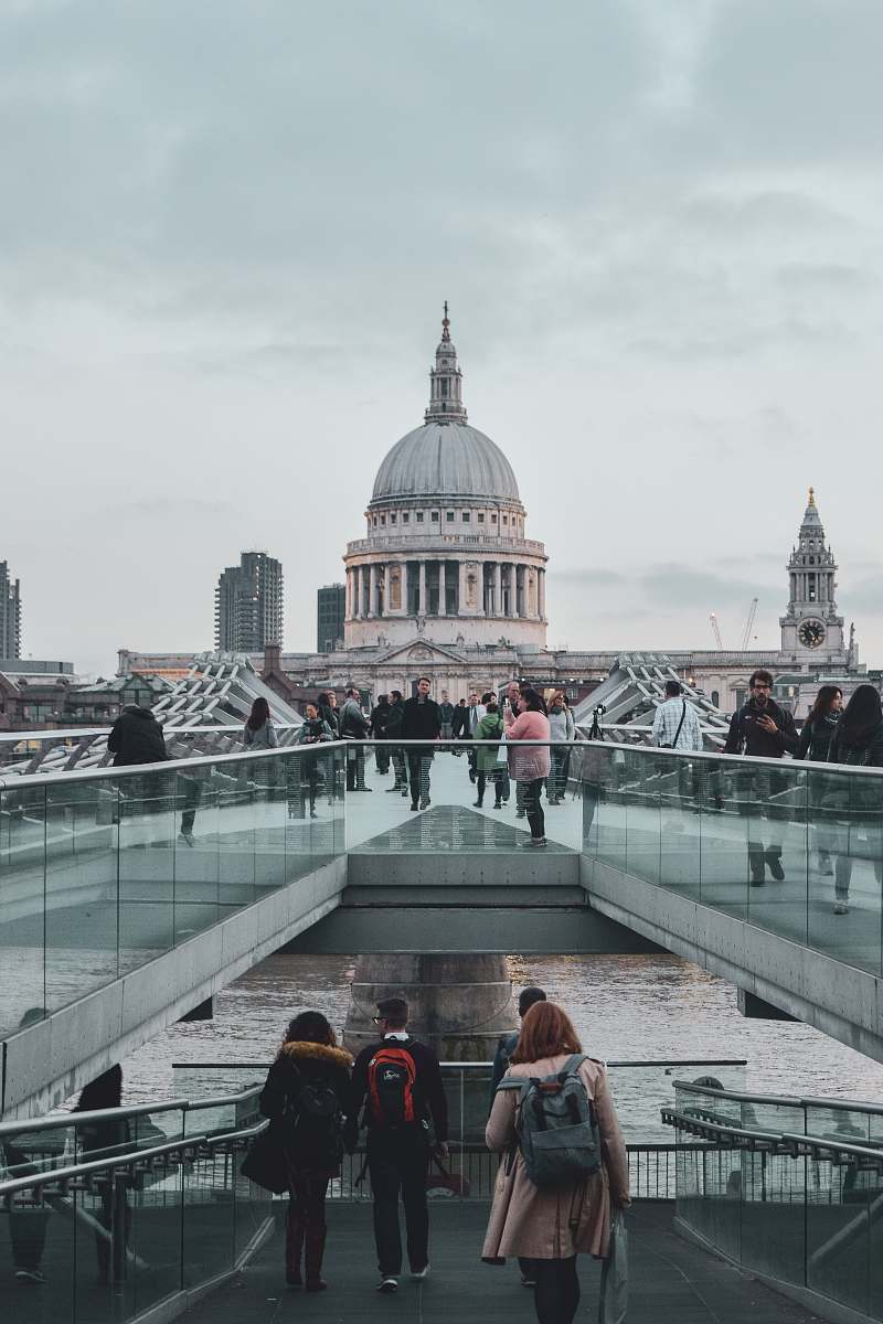building crowd walking on pathway near dome building under dramatic clouds during daytime dome
