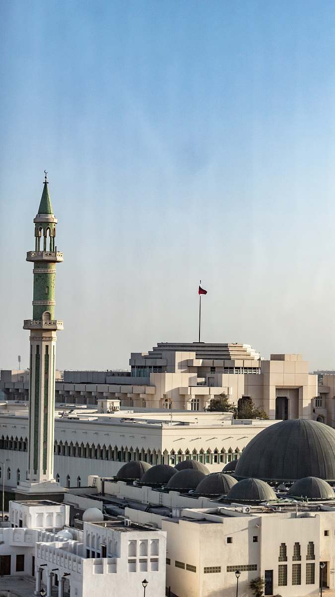building flag hoisted on top of building under clear blue sky dome