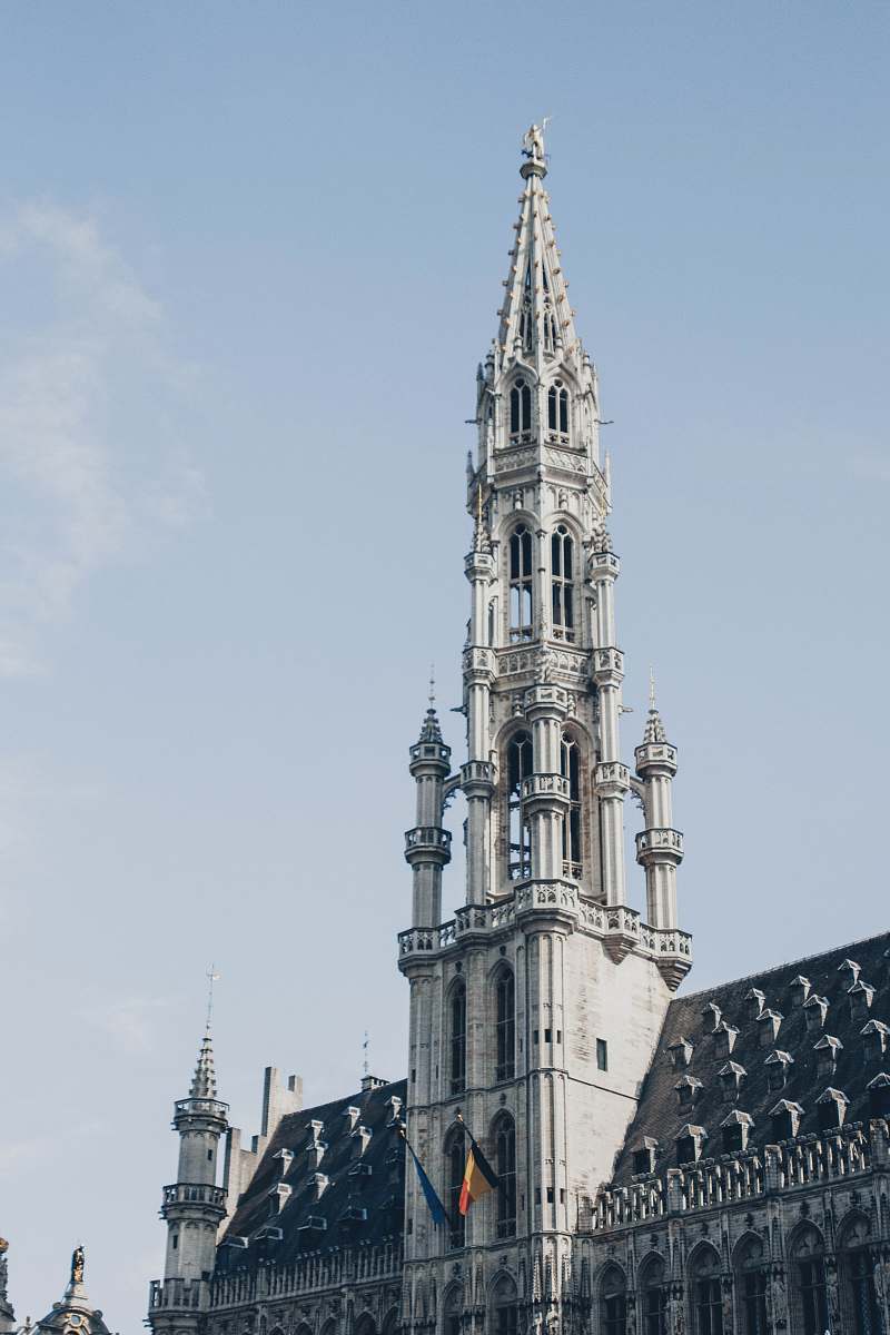 building Grand Place Market in the City of Brussels, Belgium under blue and white skies during daytime spire