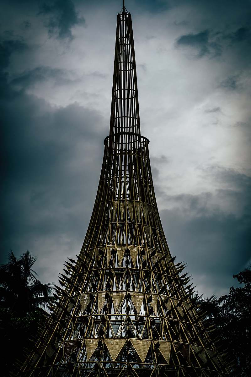 building gray and brown metal tower under cloudy sky during daytime spire