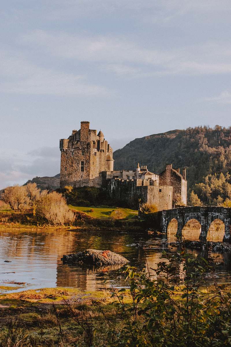 building gray castle beside river during daytime castle