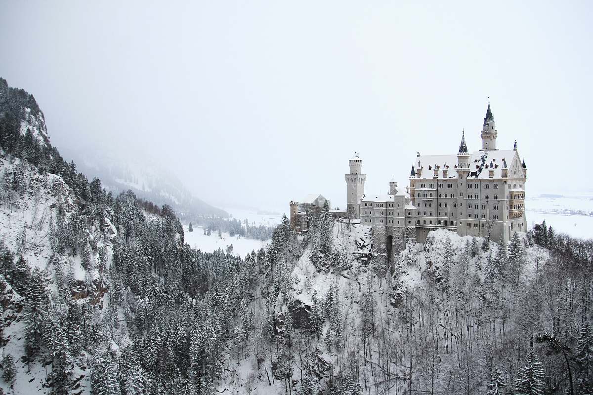 building gray concrete building on mountain covered with snow castle