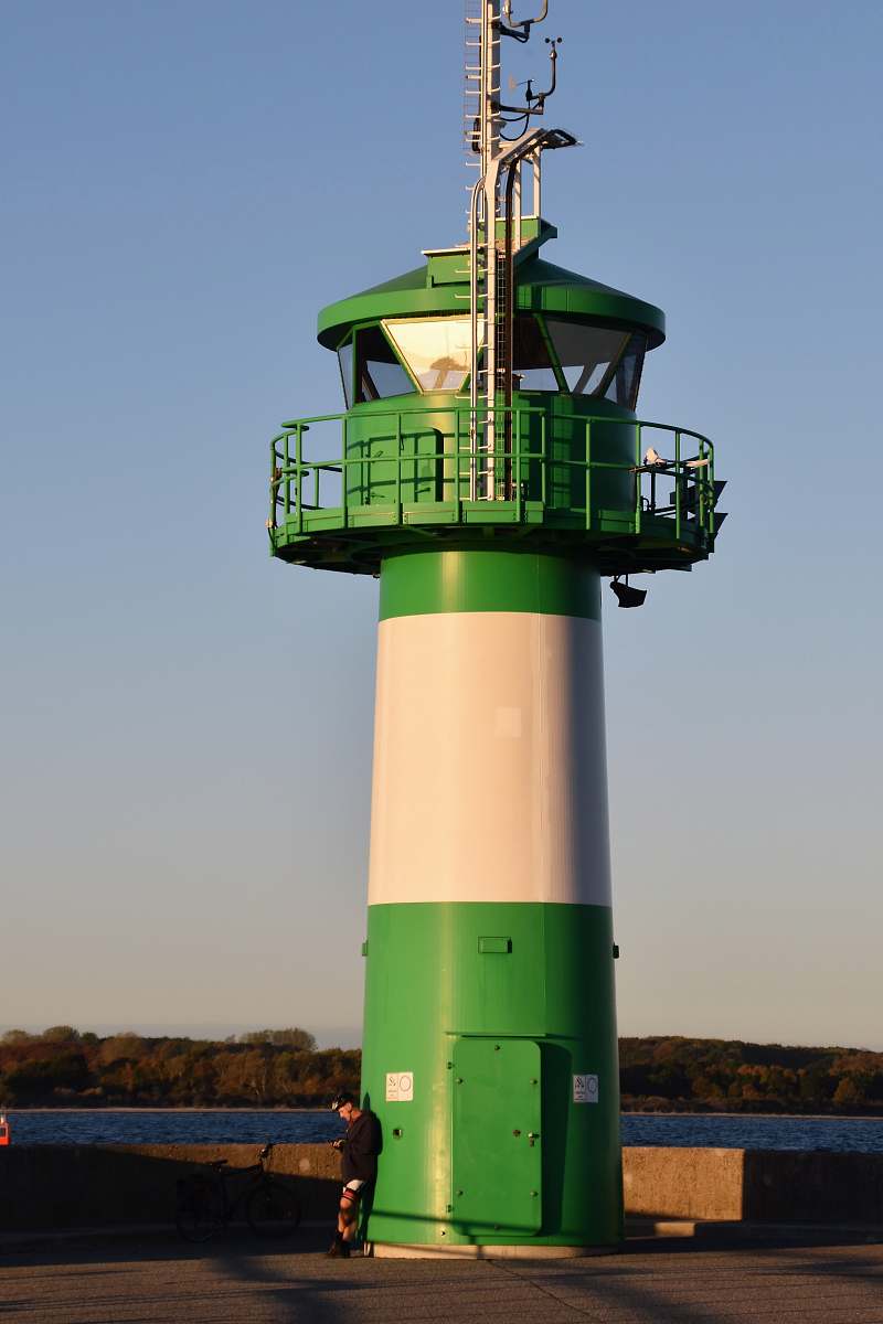 building green and white concrete lighthouse person
