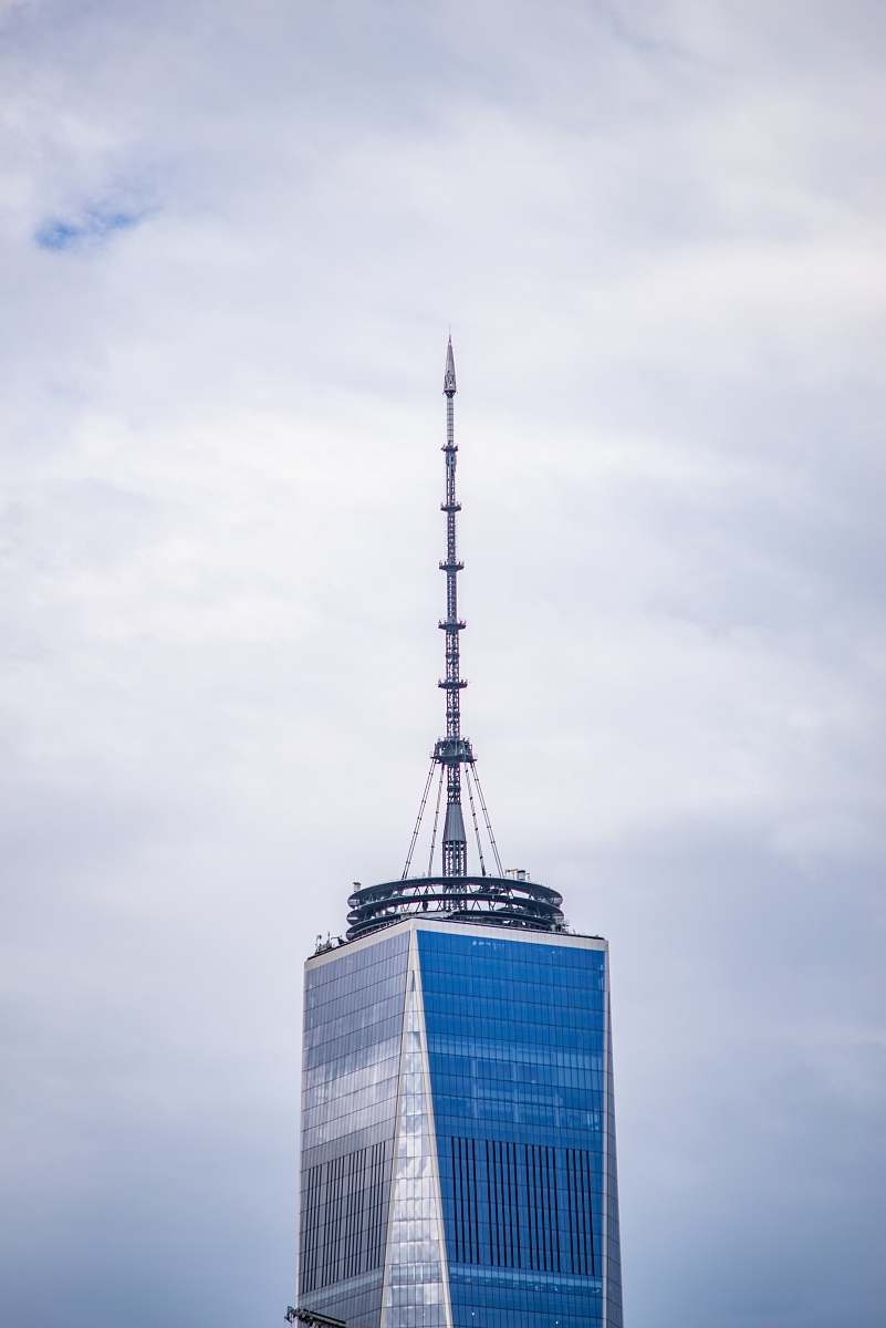 spire grey communication tower on top of blue and grey building tower