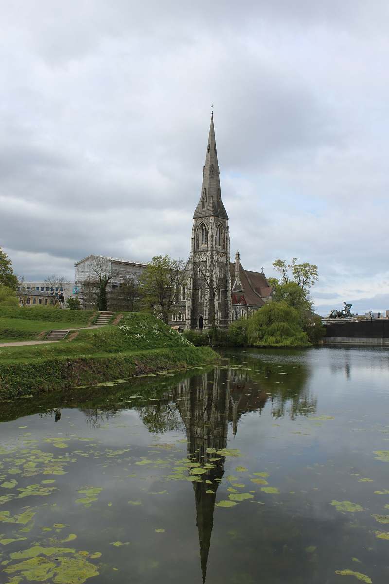 building grey concrete building near pond spire