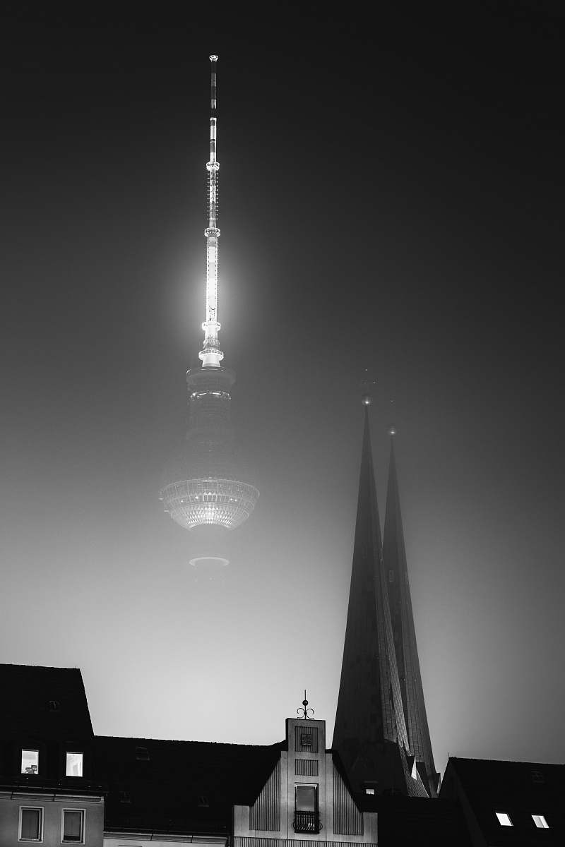 building house near tower at night black-and-white