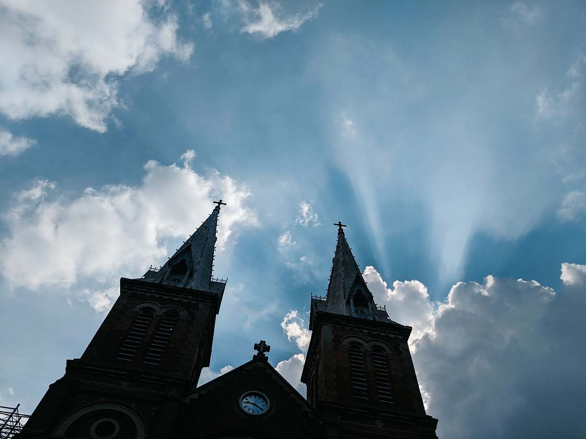 building low-angle photo silhouette of cathedral under blue sky spire