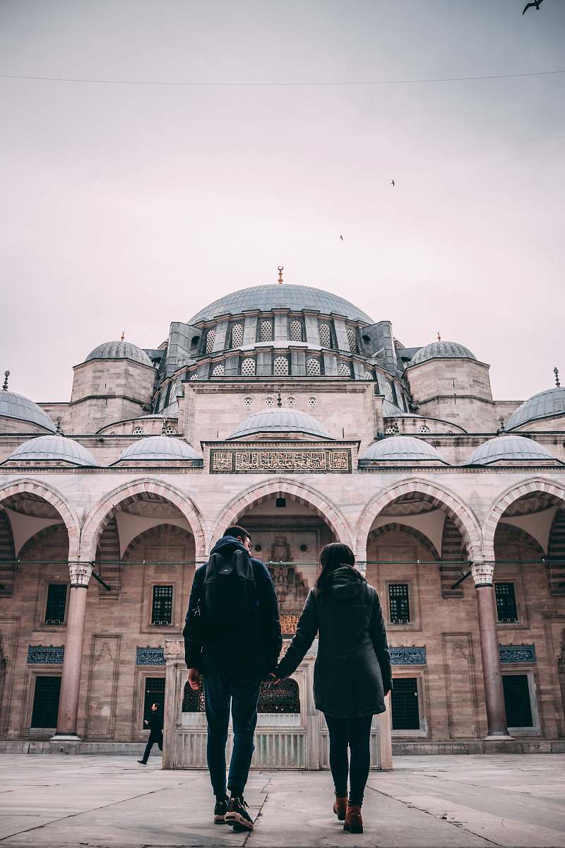 building man and woman holding hands near building dome