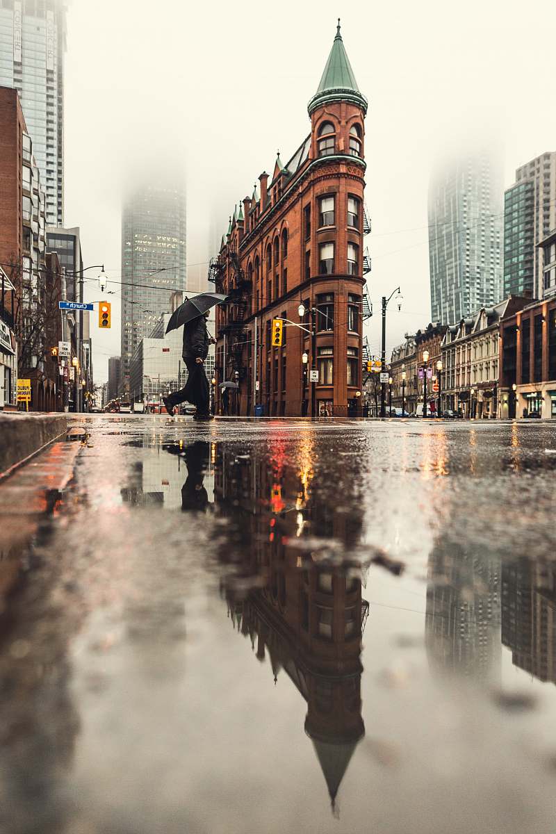 city man using umbrella crossing the street during daytime urban