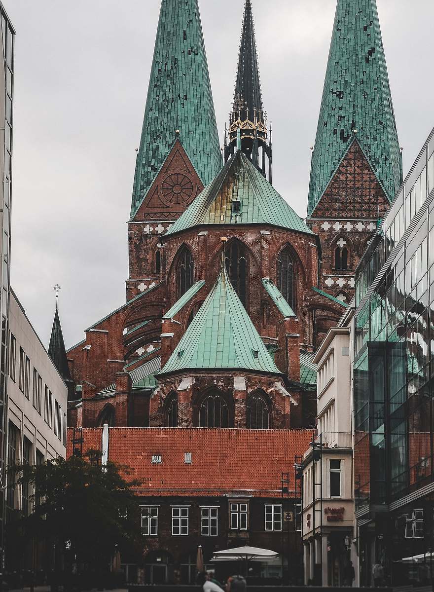 spire orange and teal building under white clouds steeple