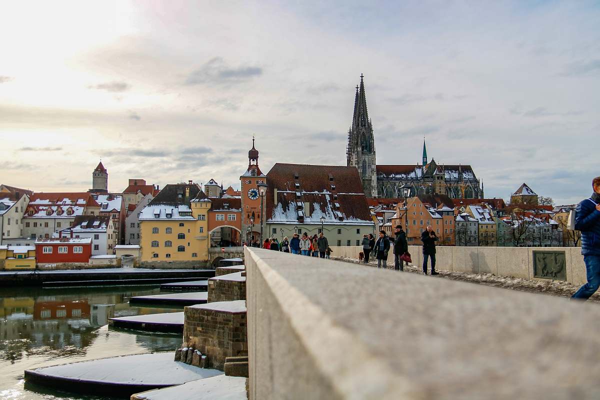 building people standing near the city during daytime spire