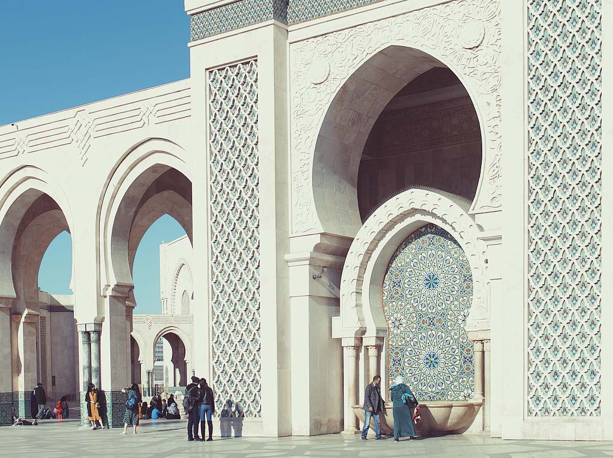 building people walking beside triumphal arch dome