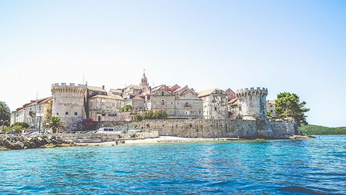castle photo of gray concrete establishment near the body of water urban