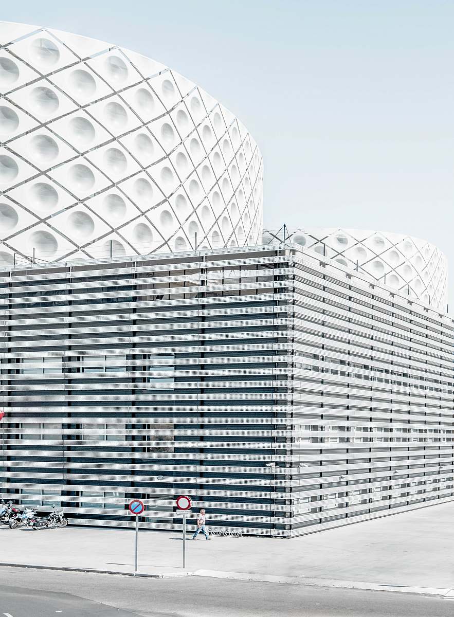 building photo of man walking beside architectural building madrid