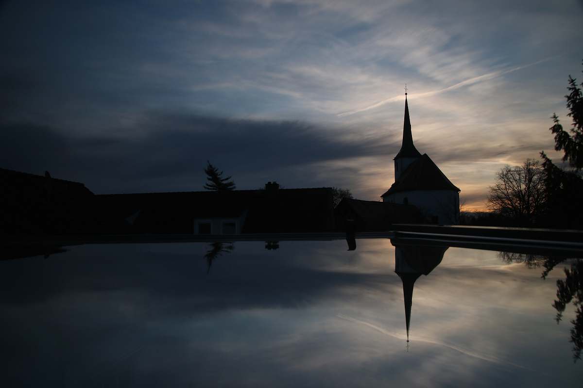 building silhouette church near body of water spire