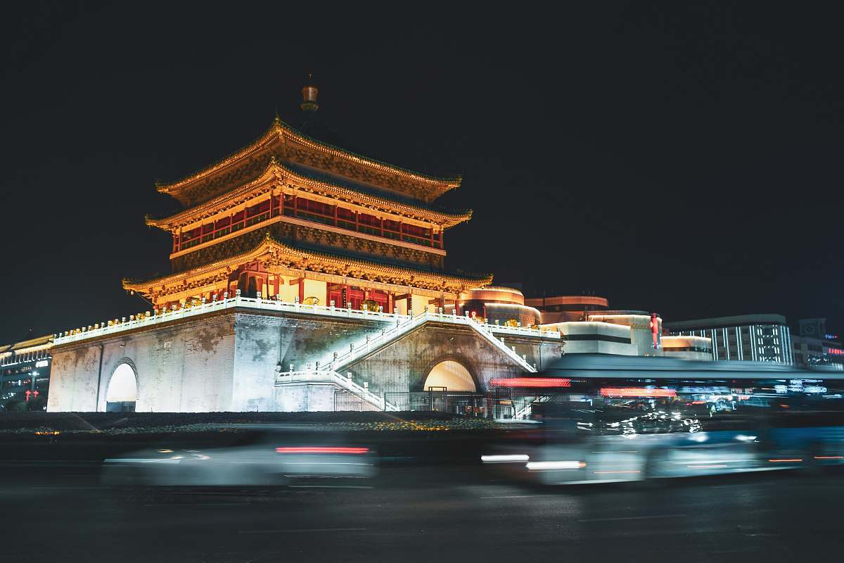 building time lapse photo of cars passing by brown building temple