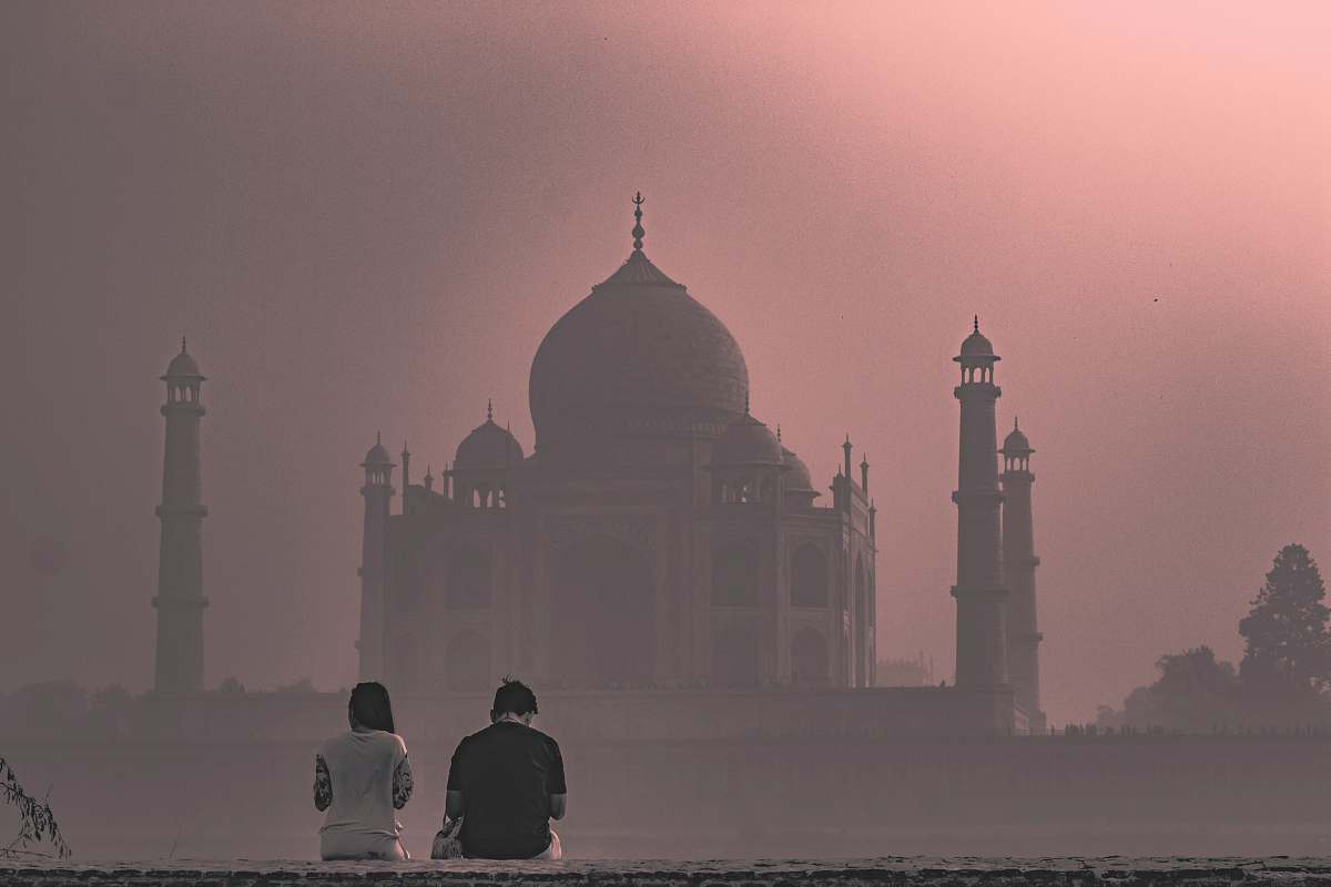 building two man and woman sitting on pavement facing on buildings ahead dome
