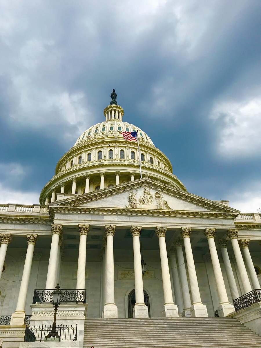 building United States Capitol in Washington D.C. under white and blue sky dome