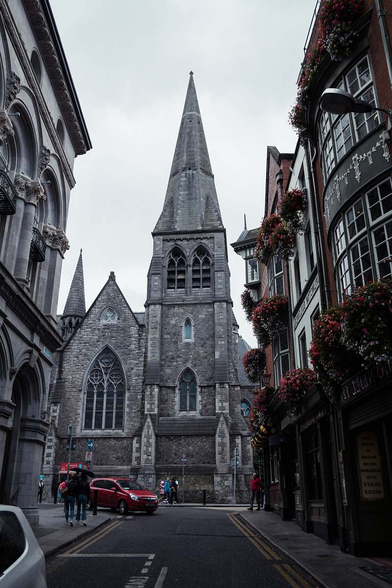 building vehicle about to pivot on a street beside a cathedral tower