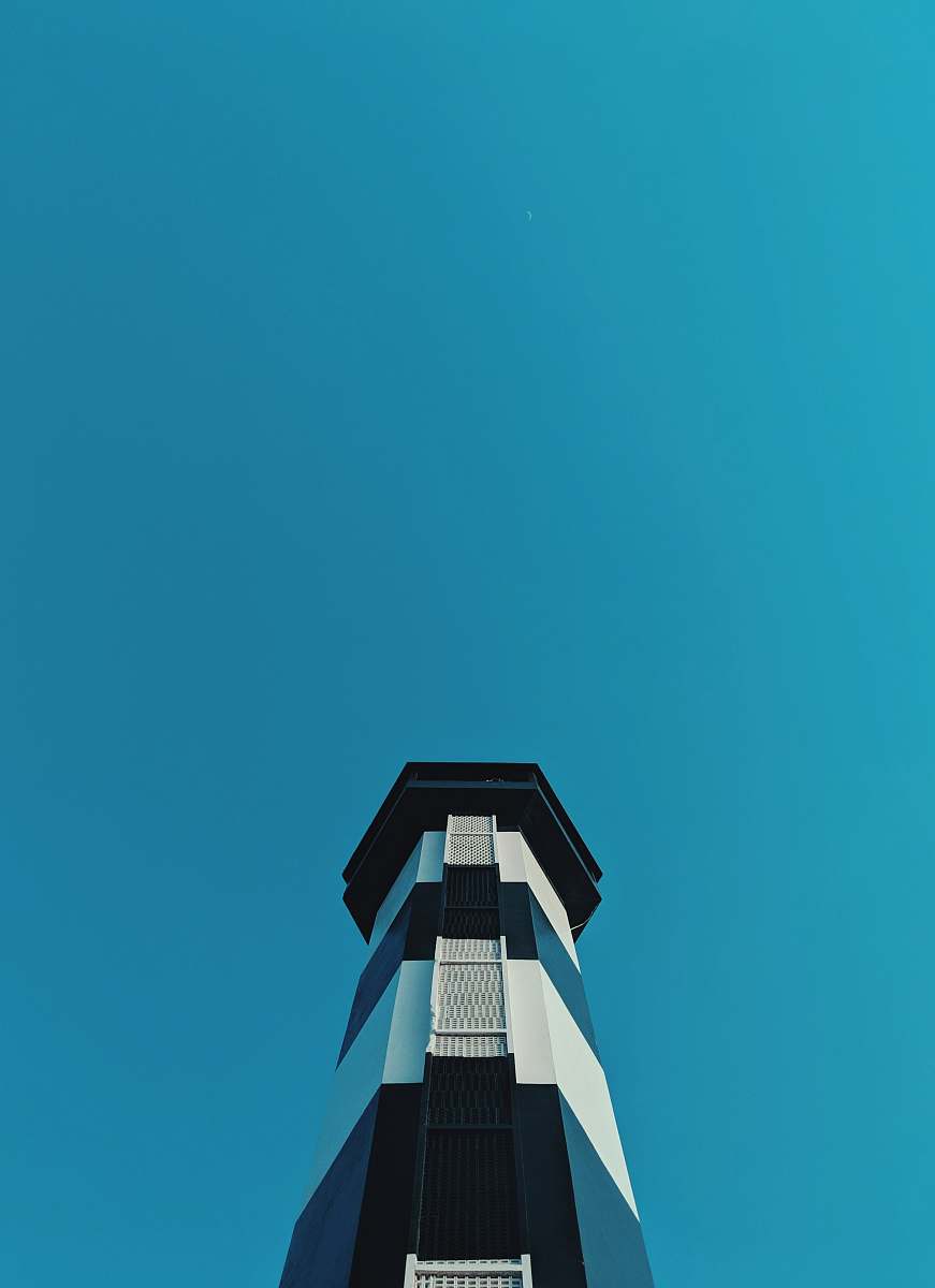 building white and blue lighthouse in low-angle photography during daytime tower