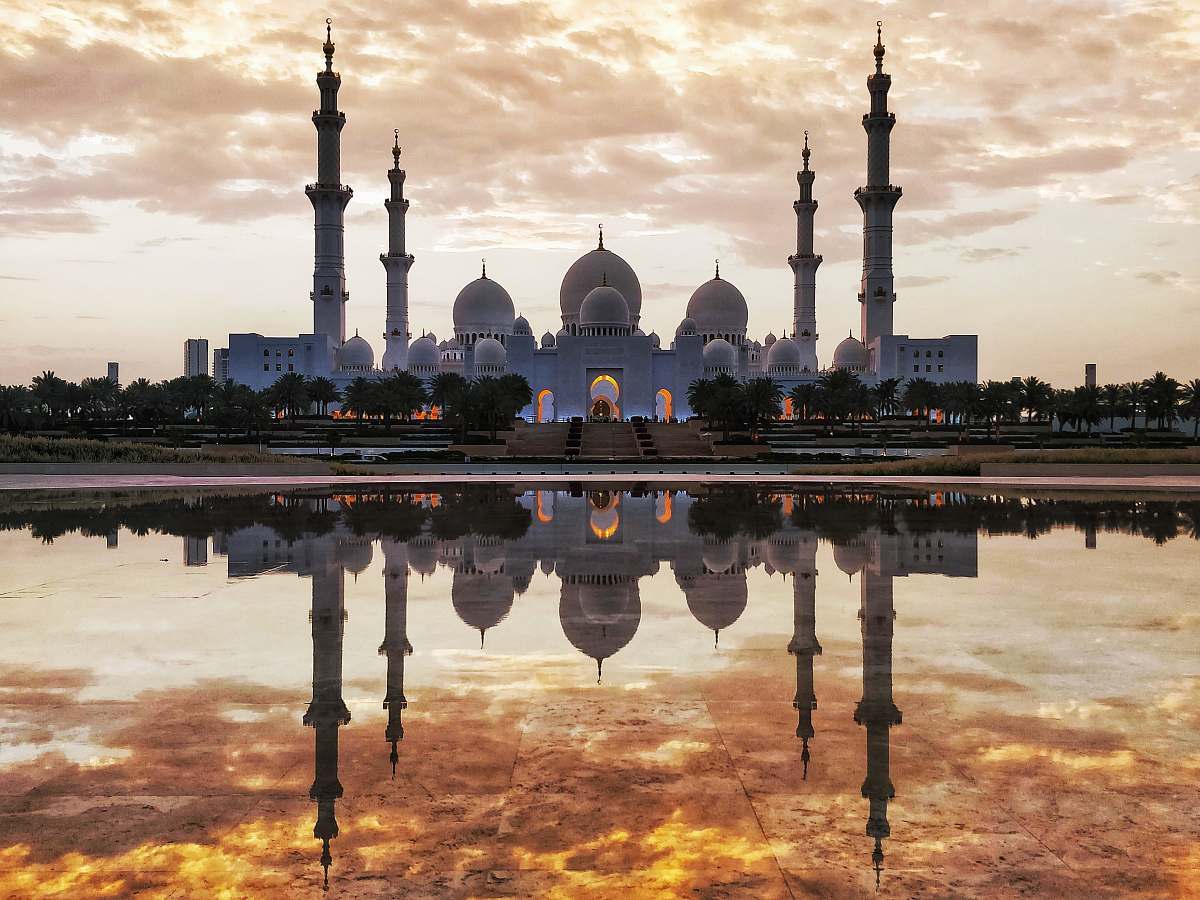building white and gray mosque in front of body of water dome