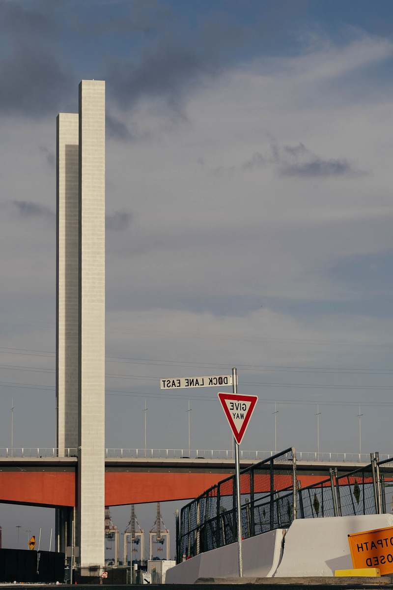 building white and red bridge under gray clouds tower