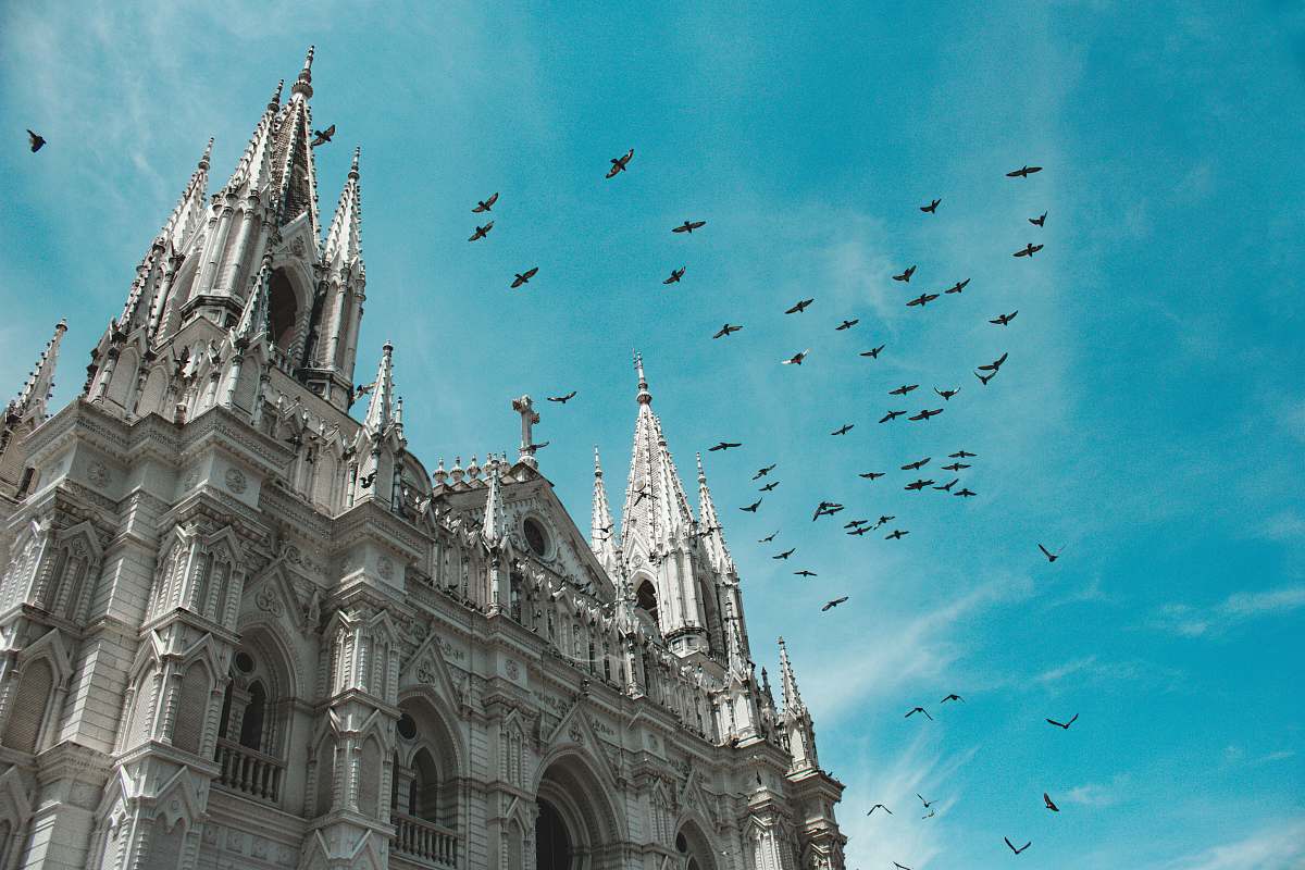 building white cathedral under blue sky spire