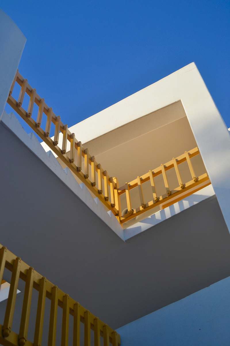 building white concrete building with yellow wooden railings window