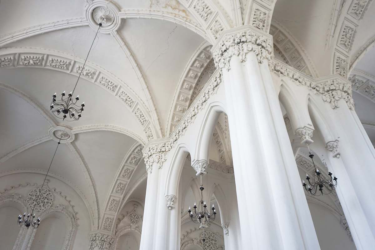 building white concrete pillared building with chandeliers arched