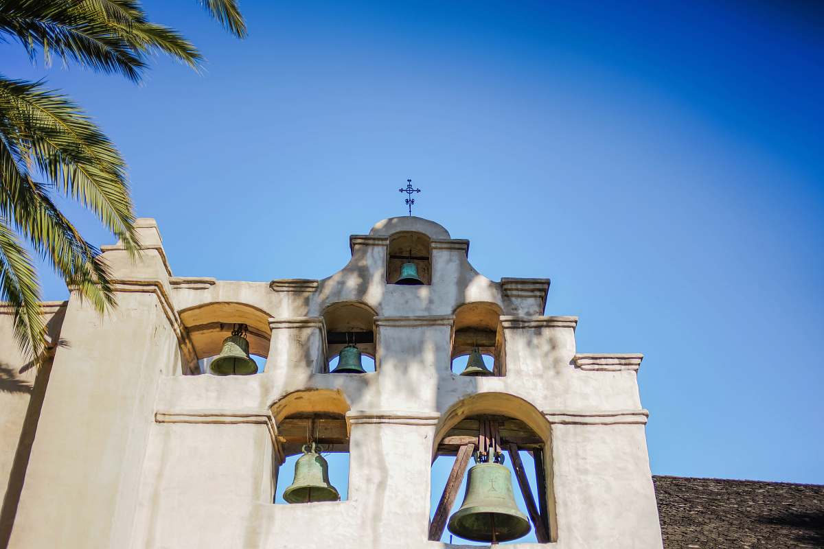 building white concrete wall with bell bell tower