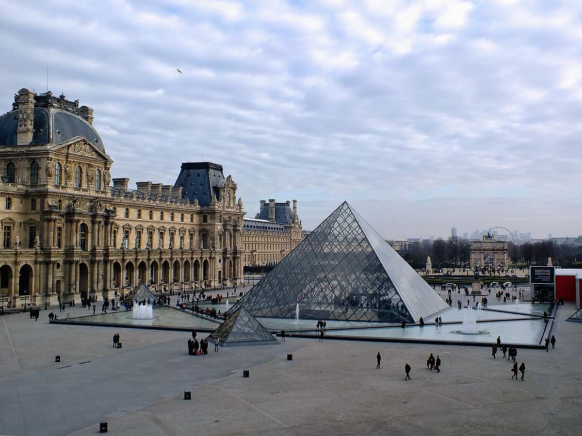 paris glass structure beside brown building pyramid