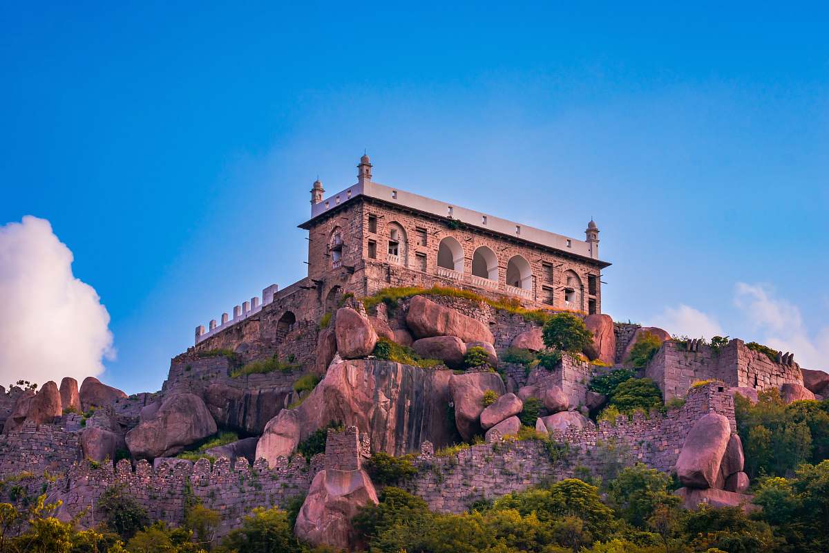 architecture low-angle photography of brown castle on cliff under blue sky housing