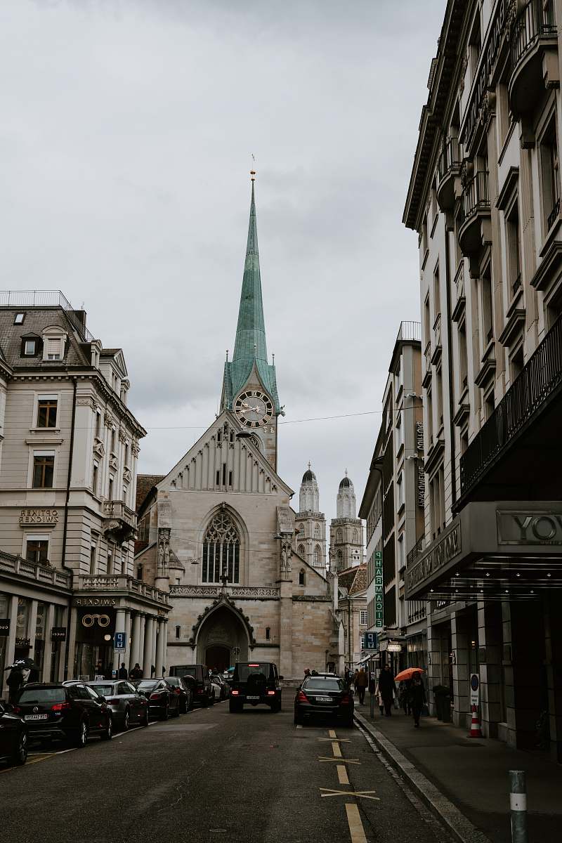 spire vehicles and buildings during daytime tower
