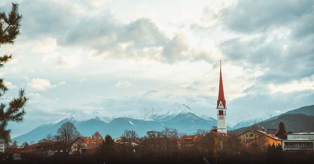 spire white and red concrete tower during daytime steeple