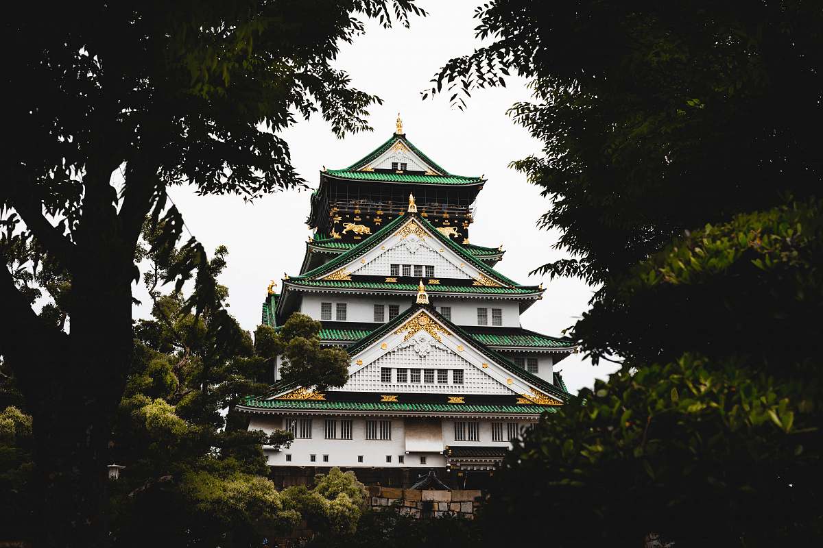 architecture white, green, and gold pagoda building surrounded by green trees pagoda