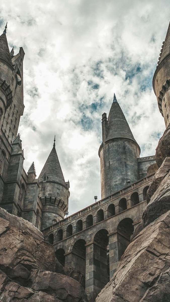 steeple white clouds hovering above grey castle spire