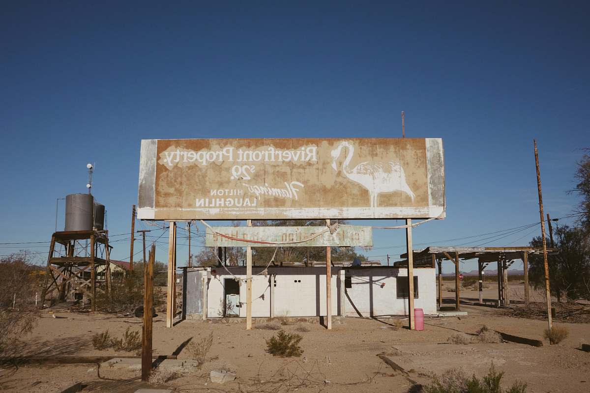 billboard Riverfront Property sign near white building during daytime amboy