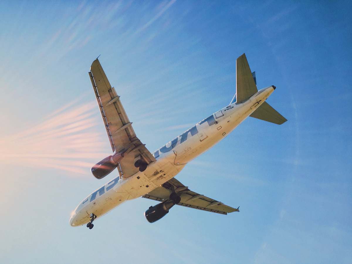 aircraft white and blue airplane under blue sky during daytime transportation