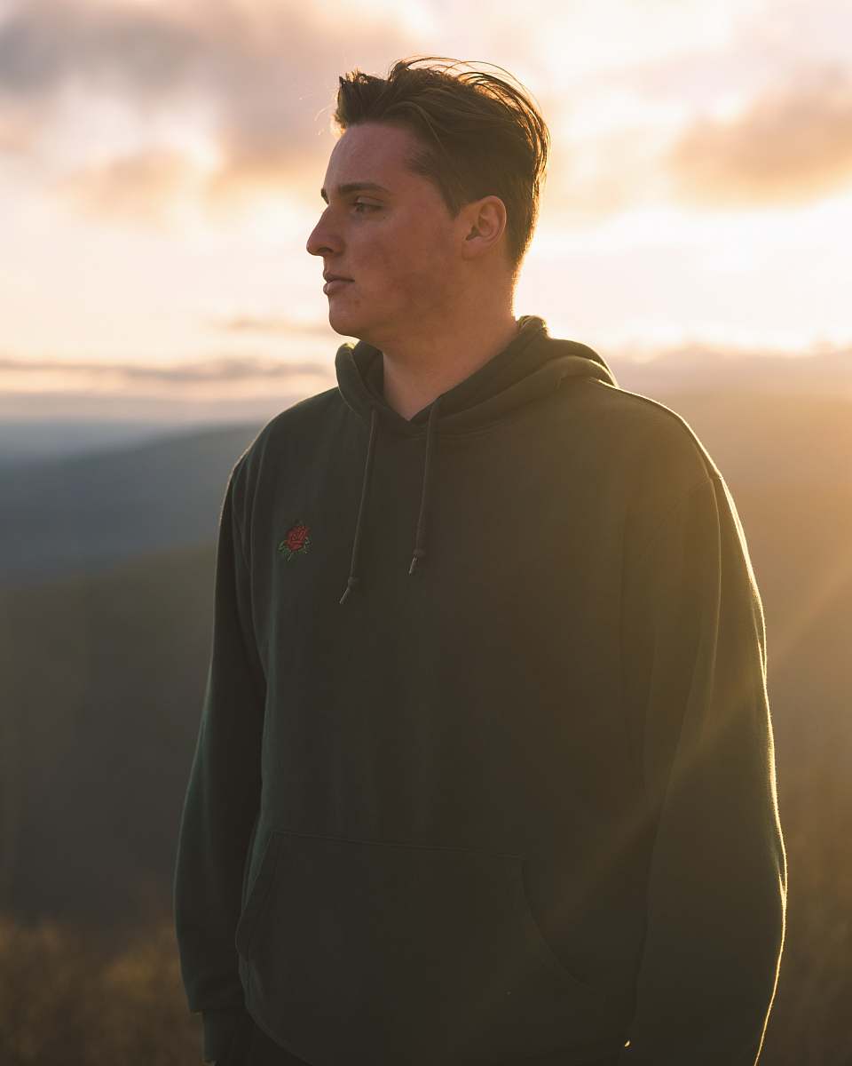 clothing man in black hoodie standing on hill during daytime human