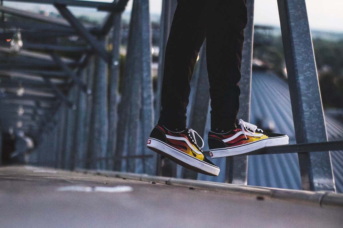 clothing person standing beside bridge railings footwear